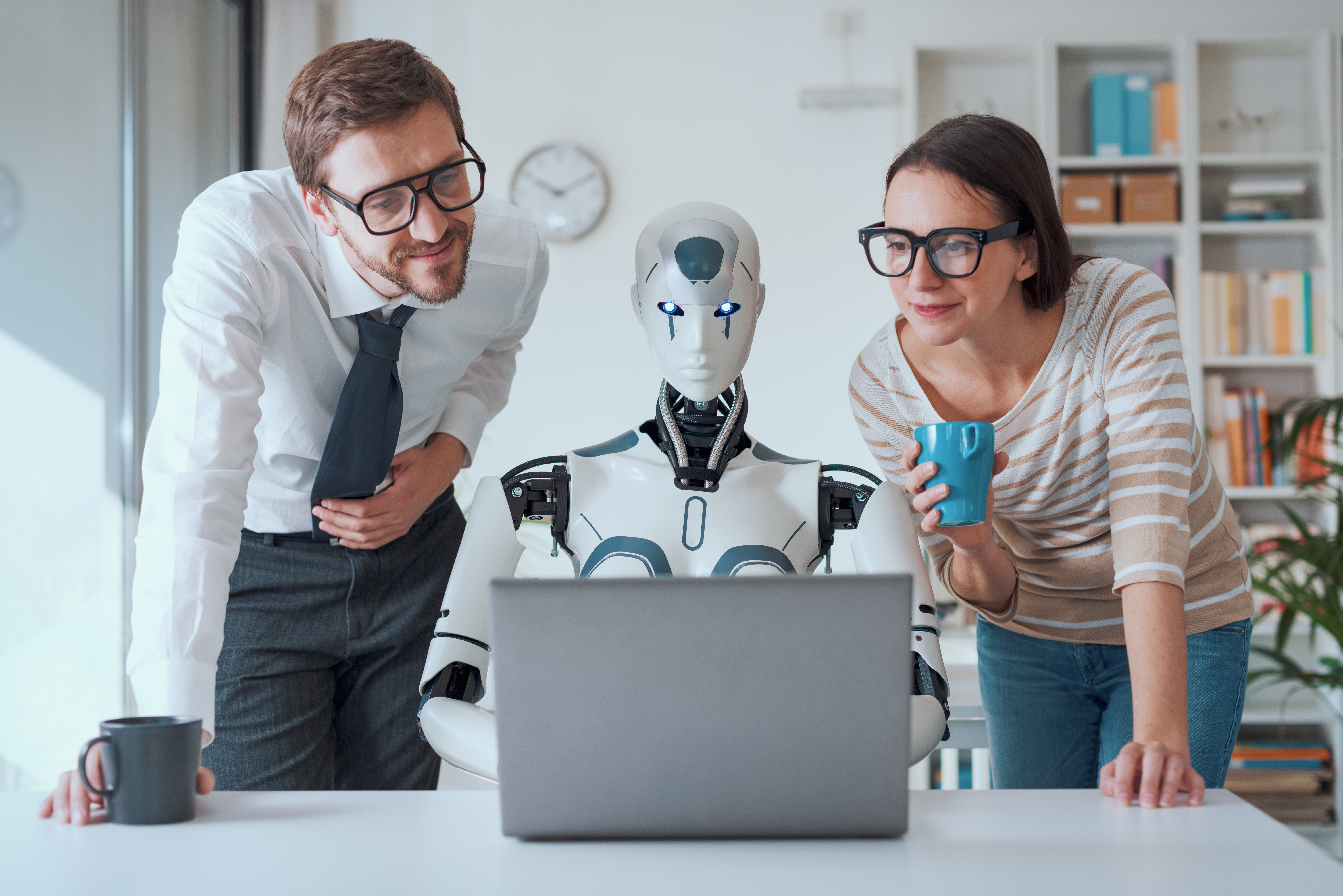 team-looking-at-laptop-with-humanoid-robot-2026-01-07-01-28-47-utc